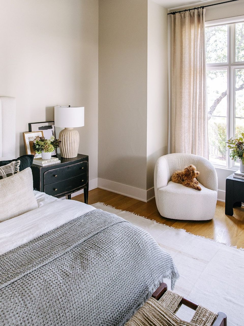 Modern bedroom with gray accent wall, black nightstand, and soft earth tones