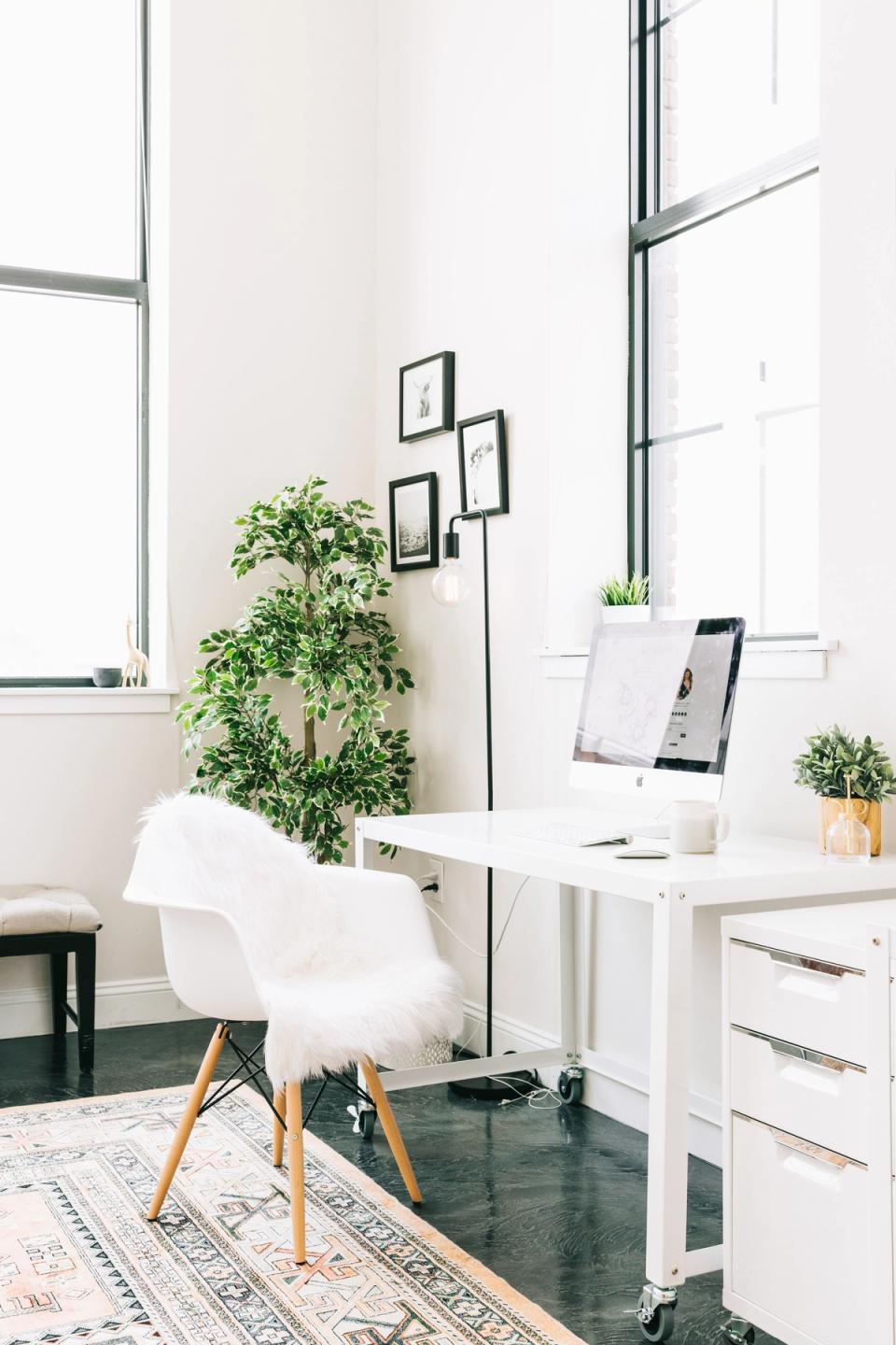 Contemporary Scandinavian desk with white chair, trailing greenery, and industrial window frames