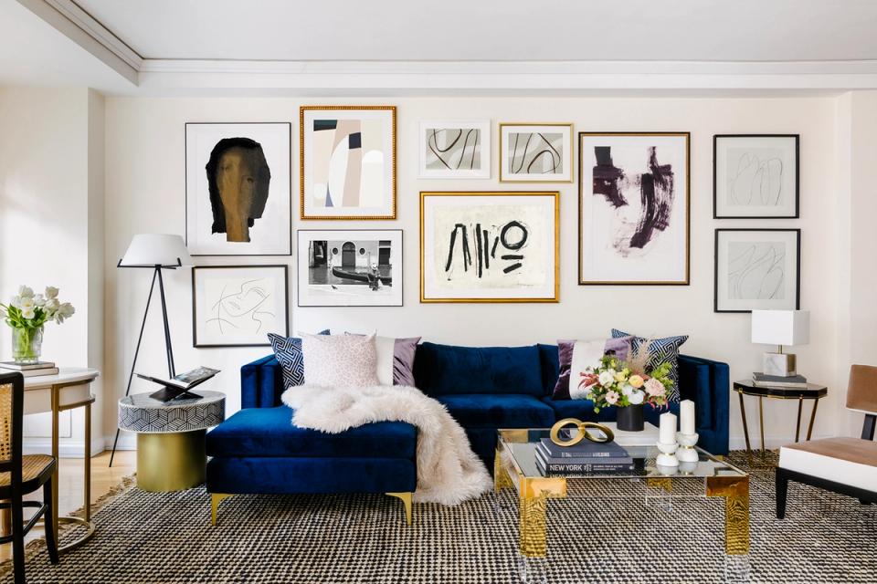 Contemporary living room with jewel-tone velvet sofa, gallery wall art display, and brass accents for sophisticated contrast