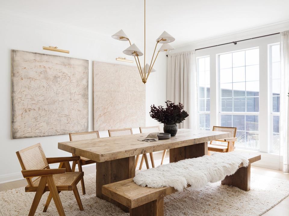 Scandinavian dining space with minimalist art, natural wood table, pendant lights, and warm neutral palette emphasizing simplicity.