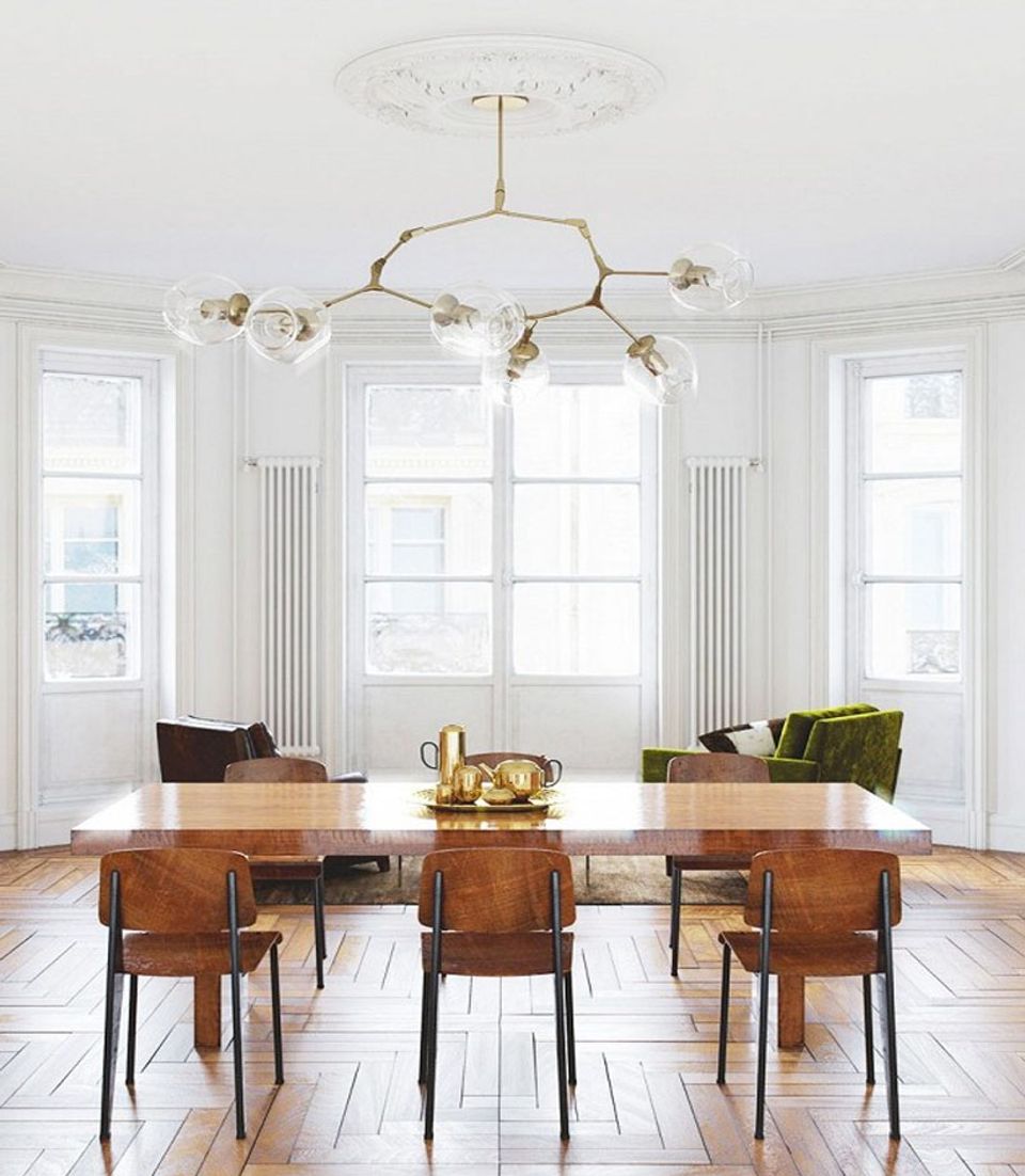 Mid-century dining space with organic brass chandelier, warm wood table, and minimalist aesthetic