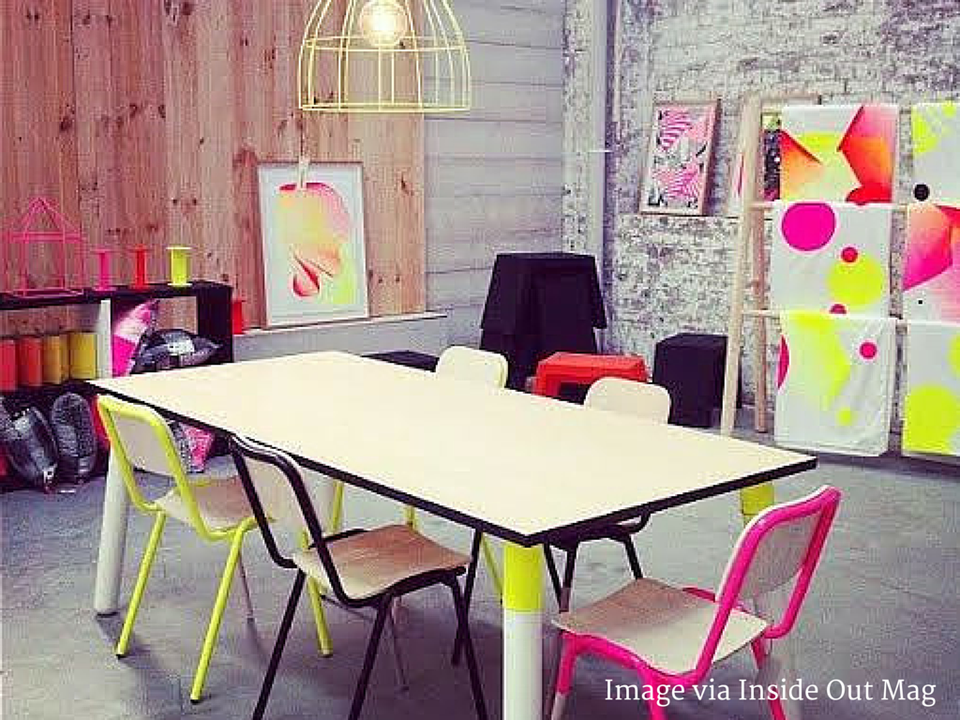 Bold neon workspace with hot pink, yellow, and lime accents in industrial setting