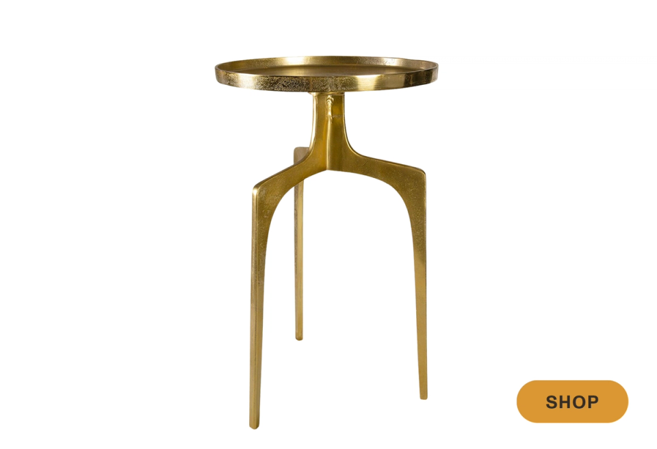 Mid-century brass martini table with geometric tripod legs and warm metallic finish