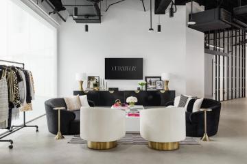 Modern black and cream lounge with brass details, curated shelving, and contemporary seating