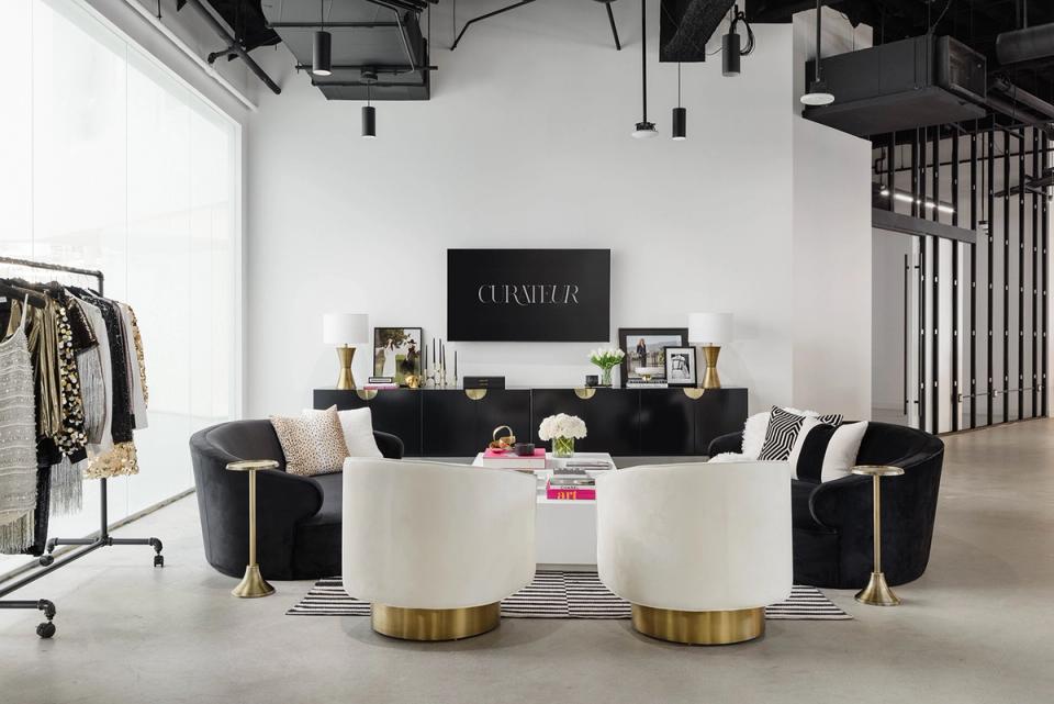 Modern black and cream lounge with brass details, curated shelving, and contemporary seating