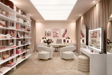 Glamorous product showroom with floor-to-ceiling shelving, cream seating, and soft neutral palette