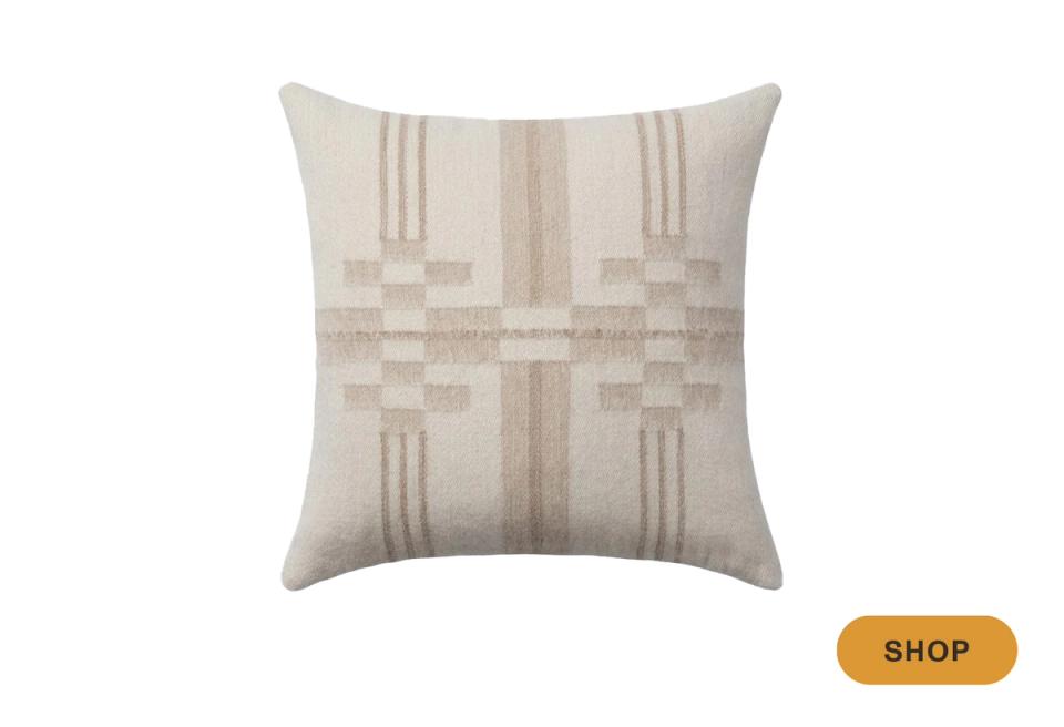 Minimalist pillow in natural tones with subtle geometric texture and linear detailing