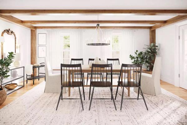 Bright farmhouse dining room with exposed wood beams, black spindle chairs, and cream neutral palette