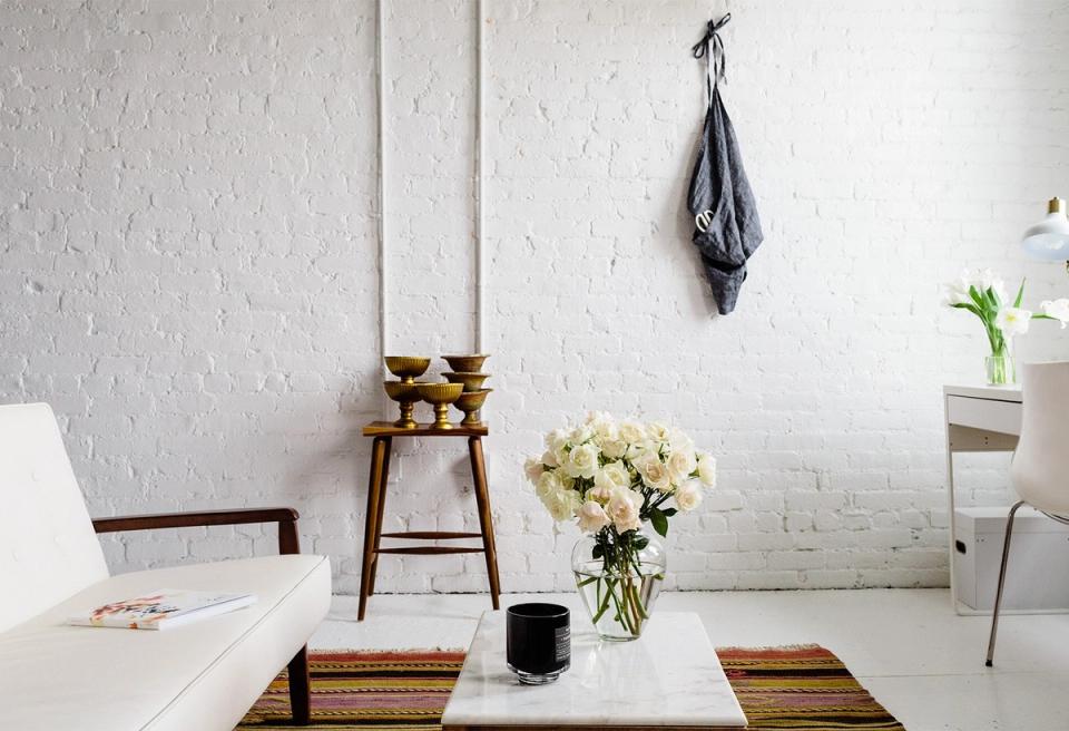 Scandinavian minimalist workspace with white brick walls, natural wood accents, and sparse styling creating calm, uncluttered atmosphere