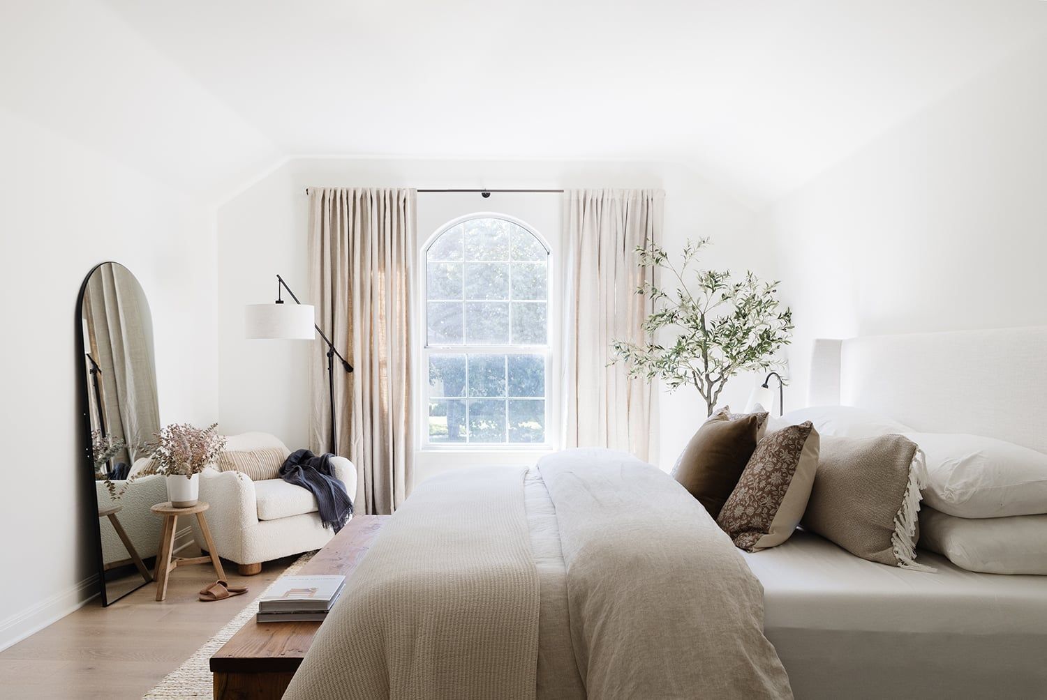 Serene organic modern bedroom with soft neutral tones, natural textures, and minimalist botanical accents