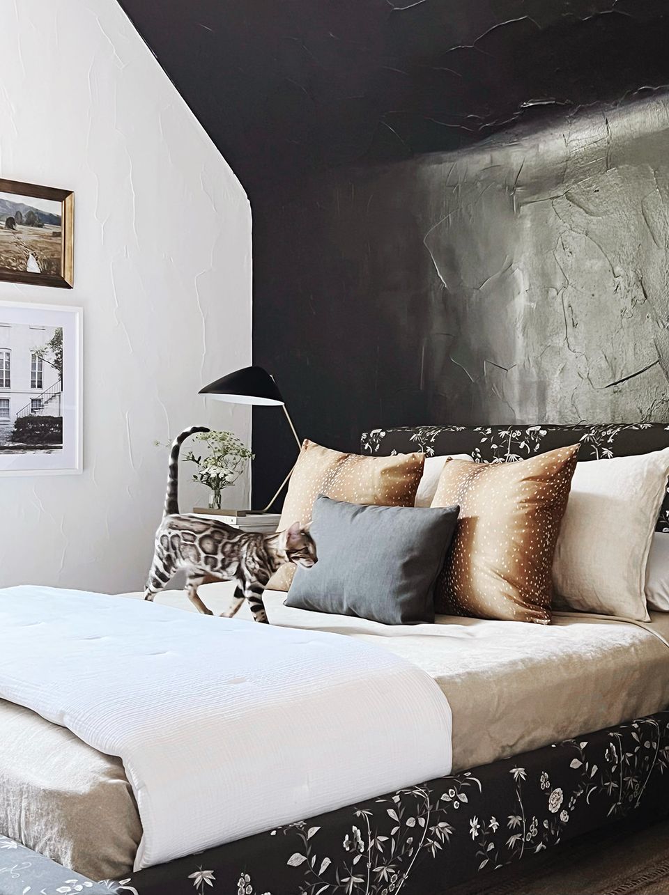 Moody luxury bedroom with black textured headboard, metallic pillows, and dramatic ambient lighting