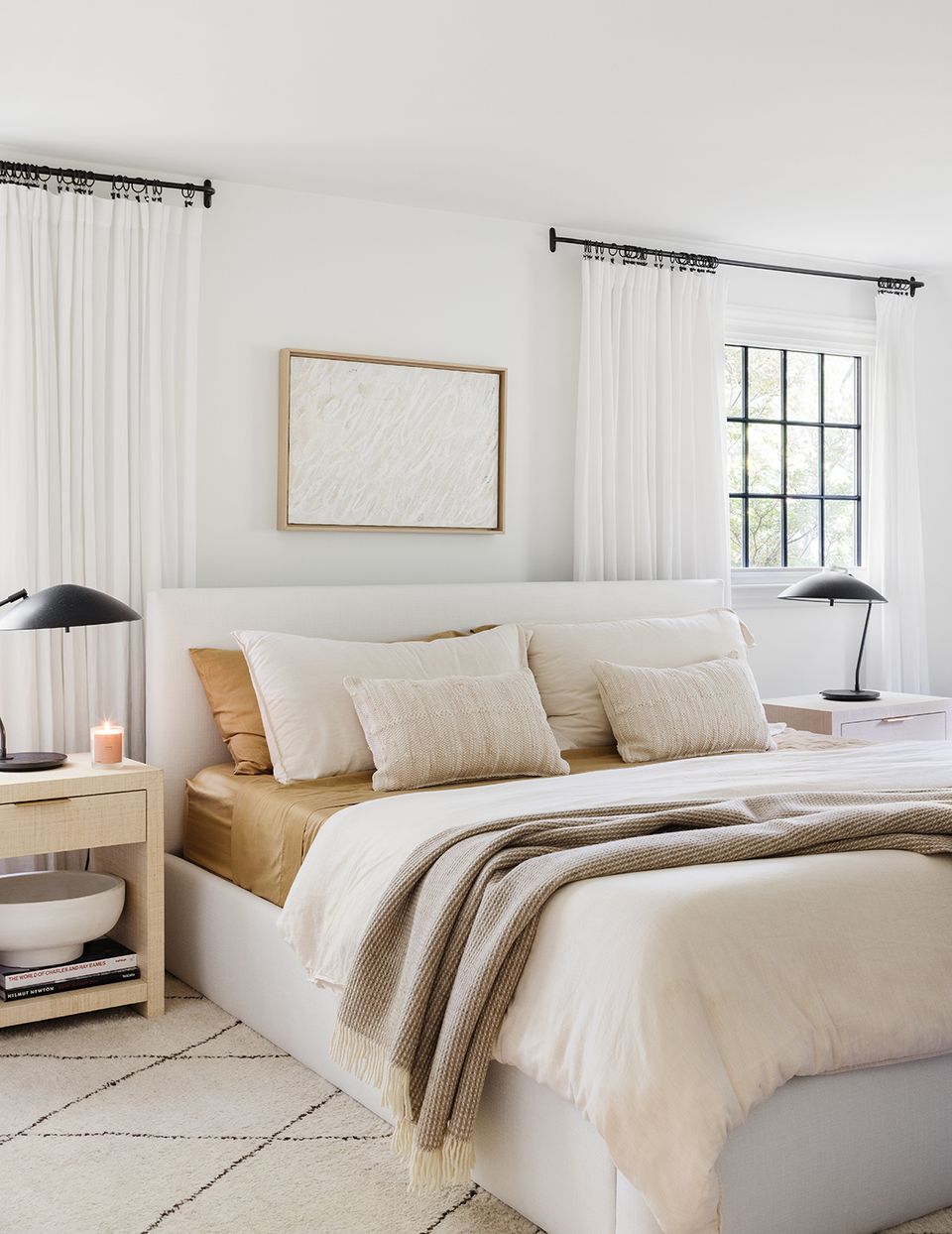 Neutral bedroom with warm wood headboard, layered bedding, and warm taupe accents