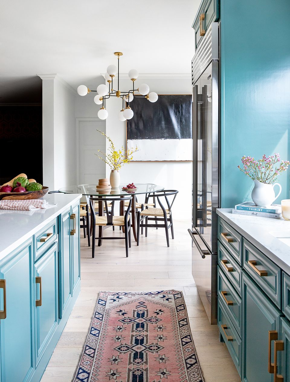 Modern farmhouse kitchen with turquoise lower cabinetry, white upper storage, and vintage Persian runner creating bold contrast
