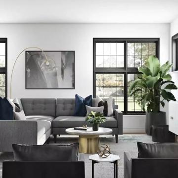 Modern living room with charcoal gray sofa, black accent wall framing, and brass accents creating a sophisticated, inviting space with abundant natural light