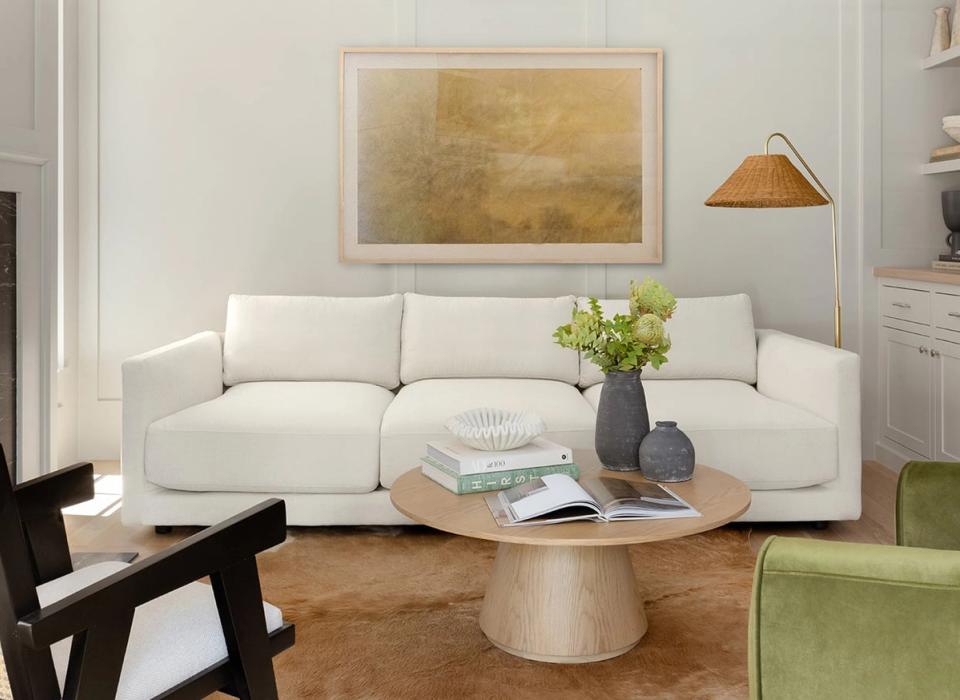 Minimalist living room with cream sofa, natural wood coffee table, and warm earth-tone accents