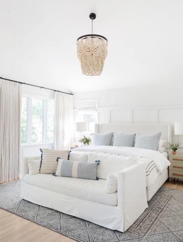 Serene coastal bedroom in cream and soft blue with woven pendant light