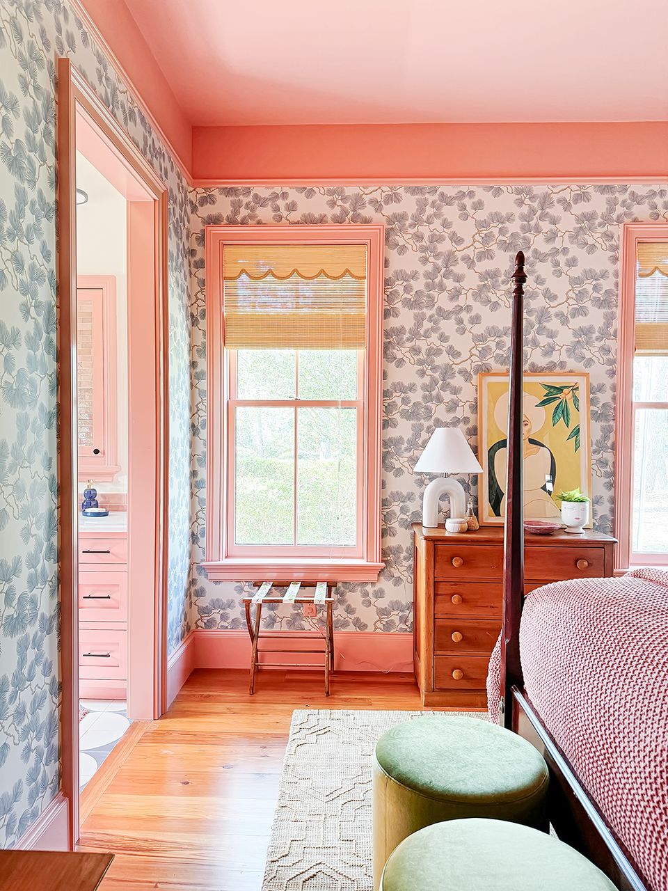 Eclectic coral and pink bedroom with patterned wallpaper, mixed furnishings, and playful energy