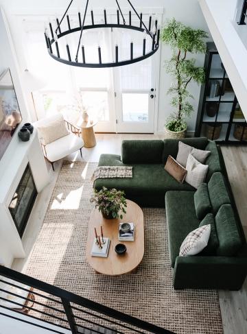 Modern farmhouse living room with forest green sofa and sculptural black chandelier