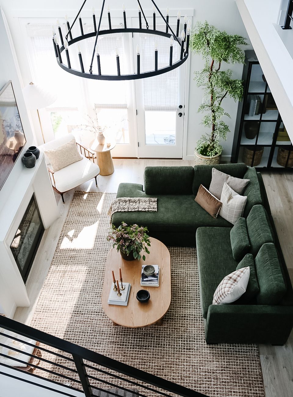 Modern farmhouse living room with forest green sofa and sculptural black chandelier