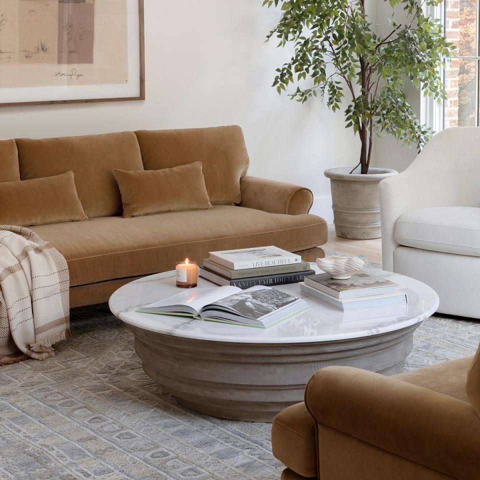 Warm minimalist living area with caramel sofa, white accents, and soft earth tones