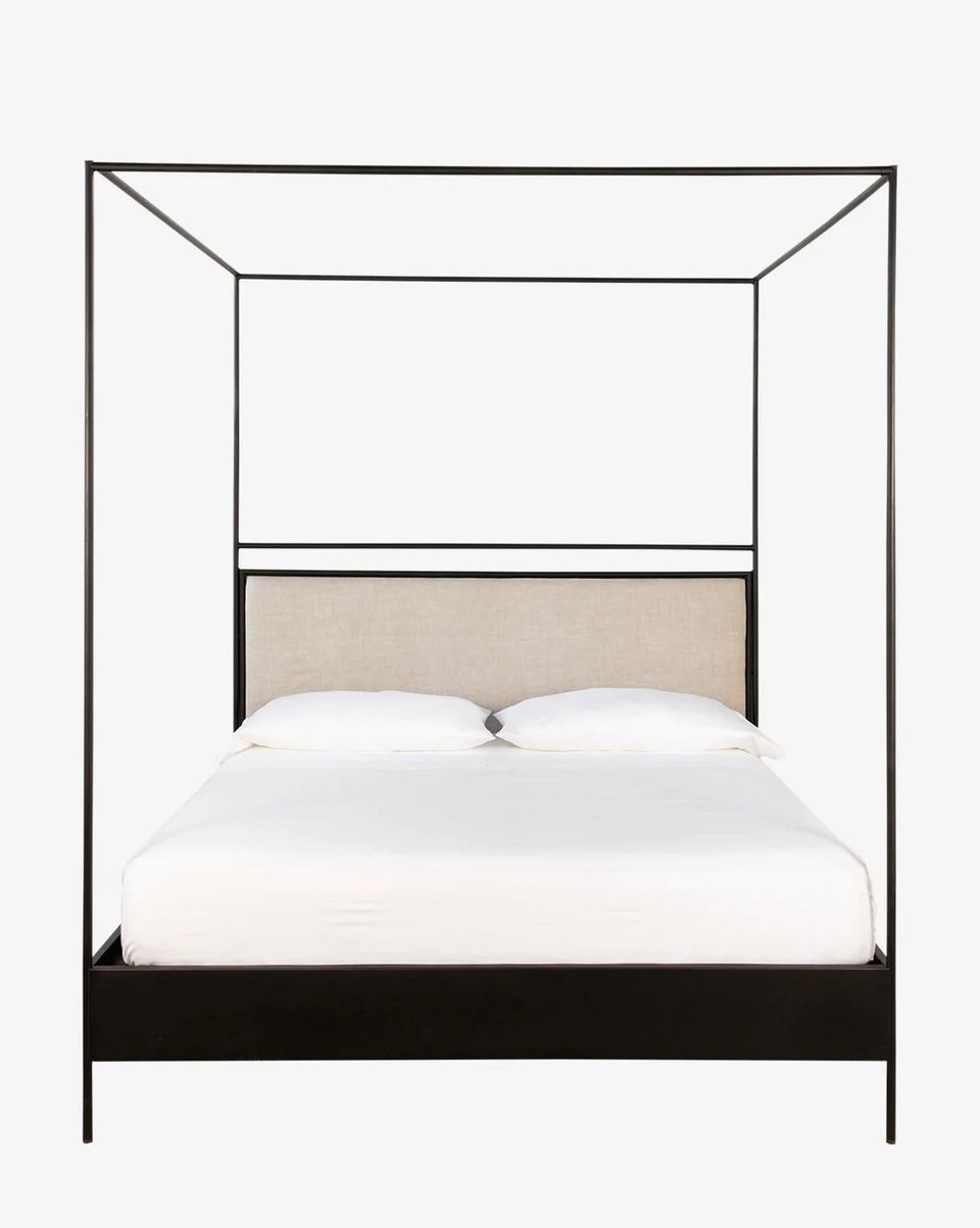 Modern industrial canopy bed with black metal frame and light wood headboard