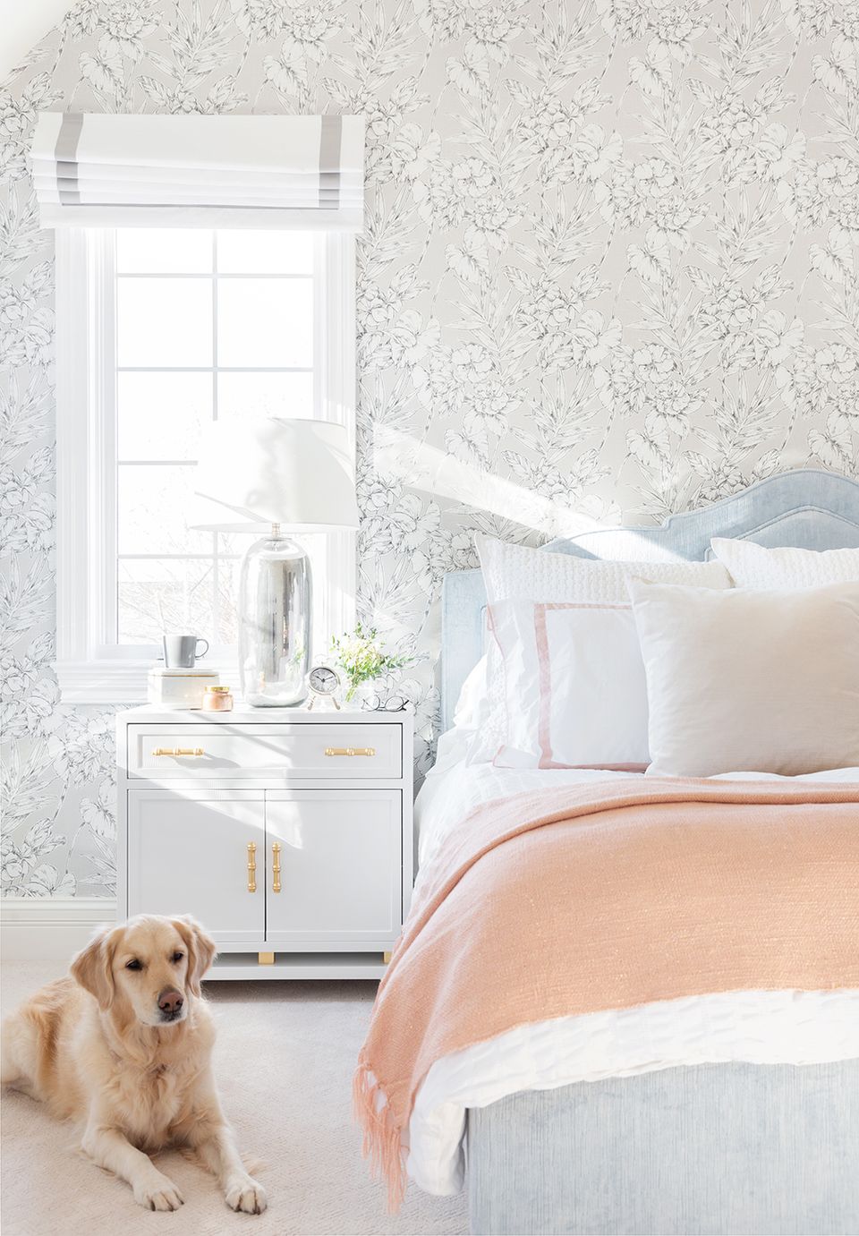 Soft, romantic bedroom with textured wallpaper, blush bedding, white nightstand, natural light, and serene, peaceful color palette.