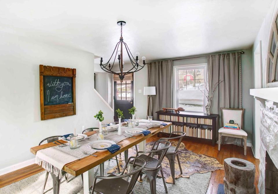 Mid-century dining room with sage green curtains, wooden table, and vintage industrial lighting