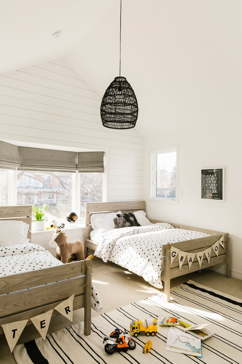 Scandinavian kids' bedroom with shiplap walls, natural wood beds, and light airy farmhouse aesthetic