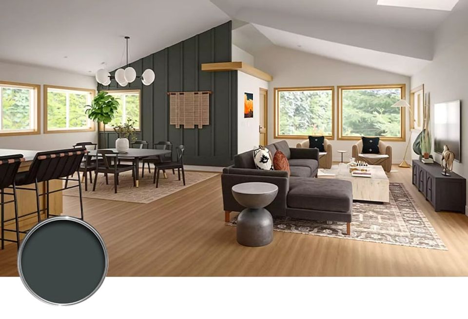 Modern open-plan living space with deep green accent wall, natural wood floors, and contemporary furnishings balancing warmth and sophistication