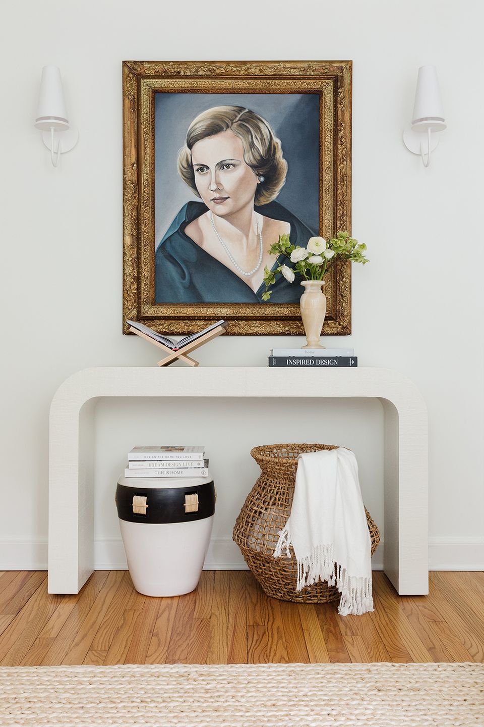 Minimalist console styling with ornate gold frame, white ceramic accent, and natural textures