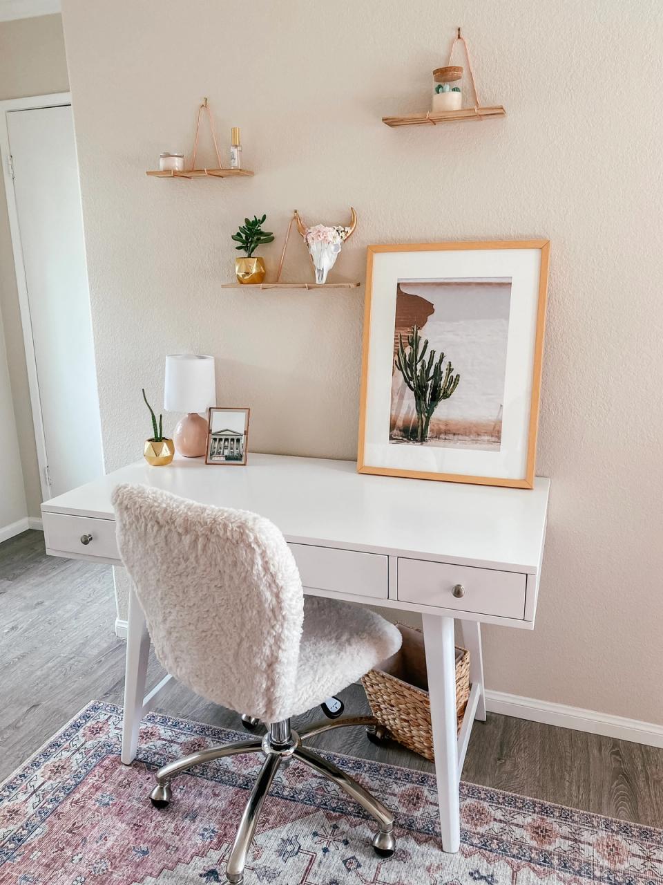 Warm, boho-inspired study nook with peachy tones, floating shelves, and cozy textured chair.