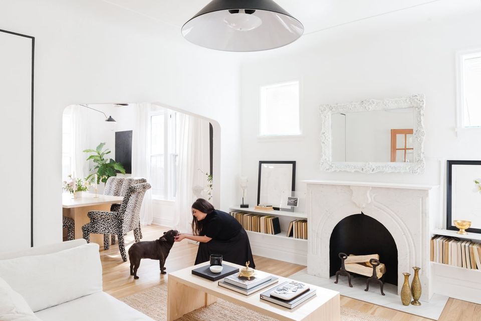 Bright minimalist living room with crisp white walls, natural wood accents, and black metal fixtures creating a clean, airy Scandinavian aesthetic.