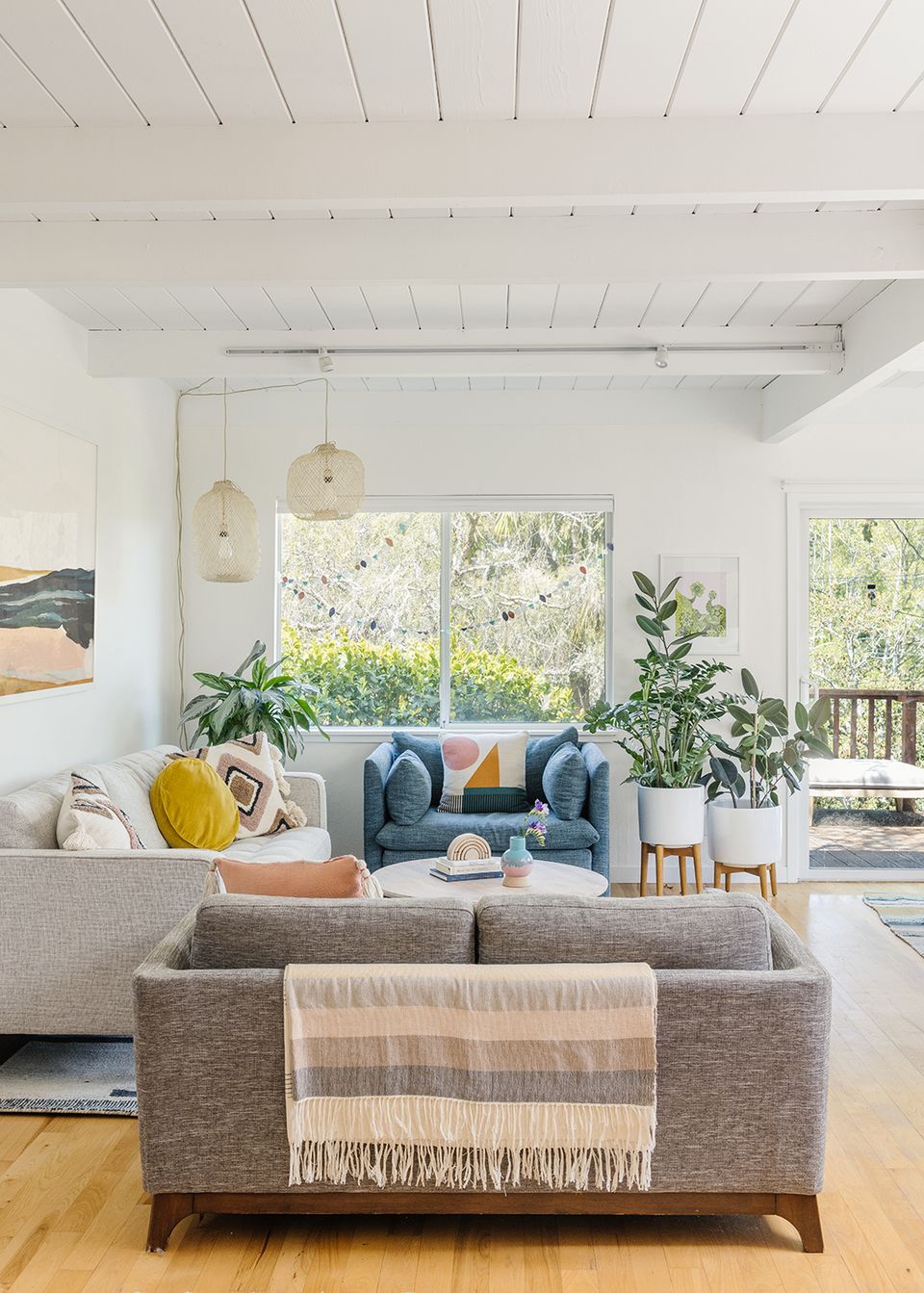 Serene minimalist boho living room with neutral tones, natural wood, and abundant greenery