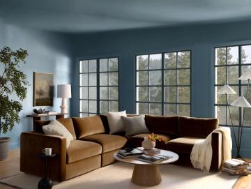 Contemporary living room with caramel sectional, slate blue walls, and modern warmth