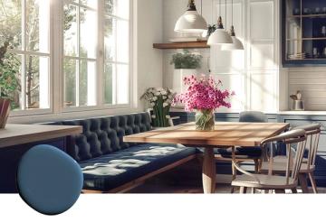 Scandinavian dining space with navy banquette seating, natural wood table, bright windows, and fresh florals