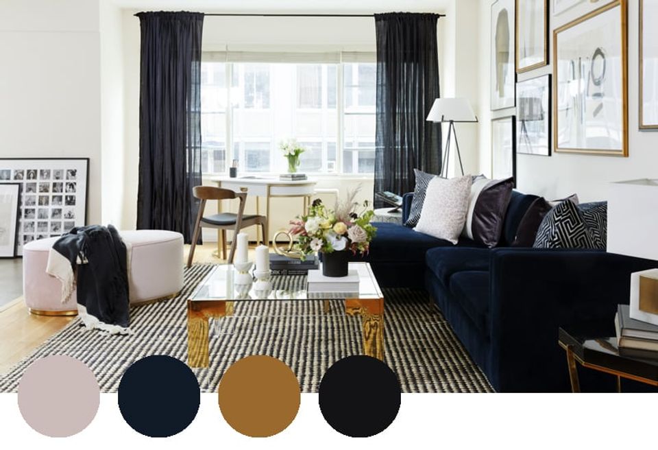 Contemporary living room blending navy, cream, gold, and black in a sophisticated palette with striped textiles and natural light
