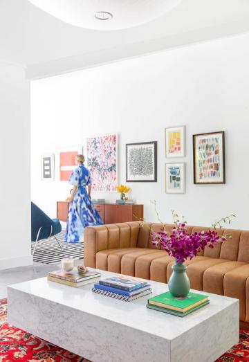 Contemporary colorful living room with caramel leather sofa and marble-top coffee table