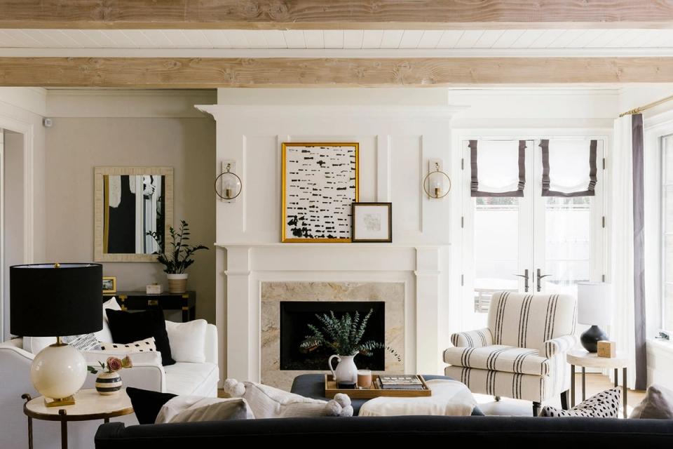 Modern living room with fireplace, black and cream palette, shiplap walls, and layered lighting balancing warmth and style.