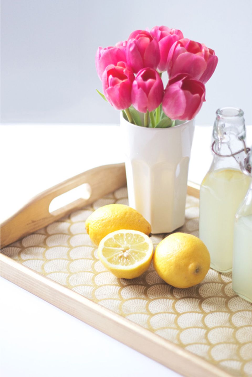 Bright minimalist table styling with geometric patterned wooden tray and fresh spring florals