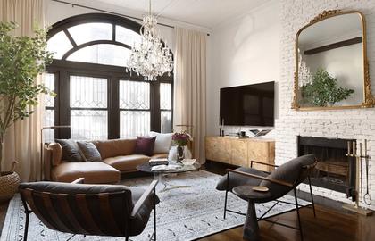 Warm transitional living room with brick fireplace, arched windows, and brown leather seating