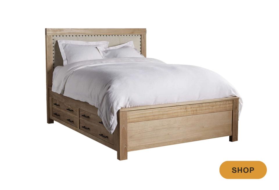 Farmhouse storage bed with nailhead-trim headboard and natural wood in soft whitewash