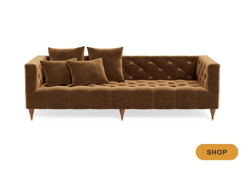Mid-century modern camel sofa with button tufting, tapered wooden legs, and warm neutral tone