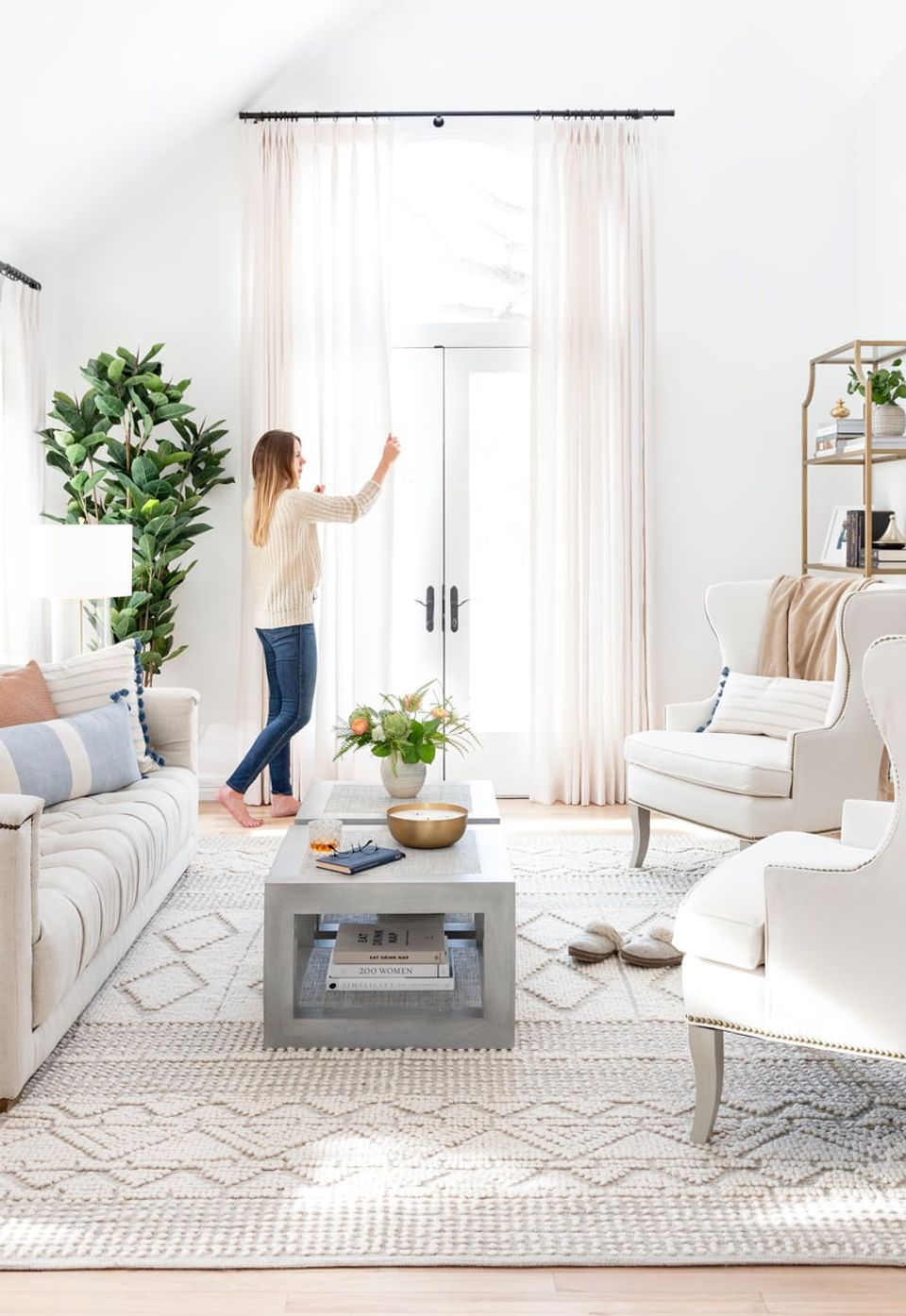 Bright scandinavian-inspired living room with full-length cream curtains, neutral furnishings, and abundant natural light establishing an open, serene mood.