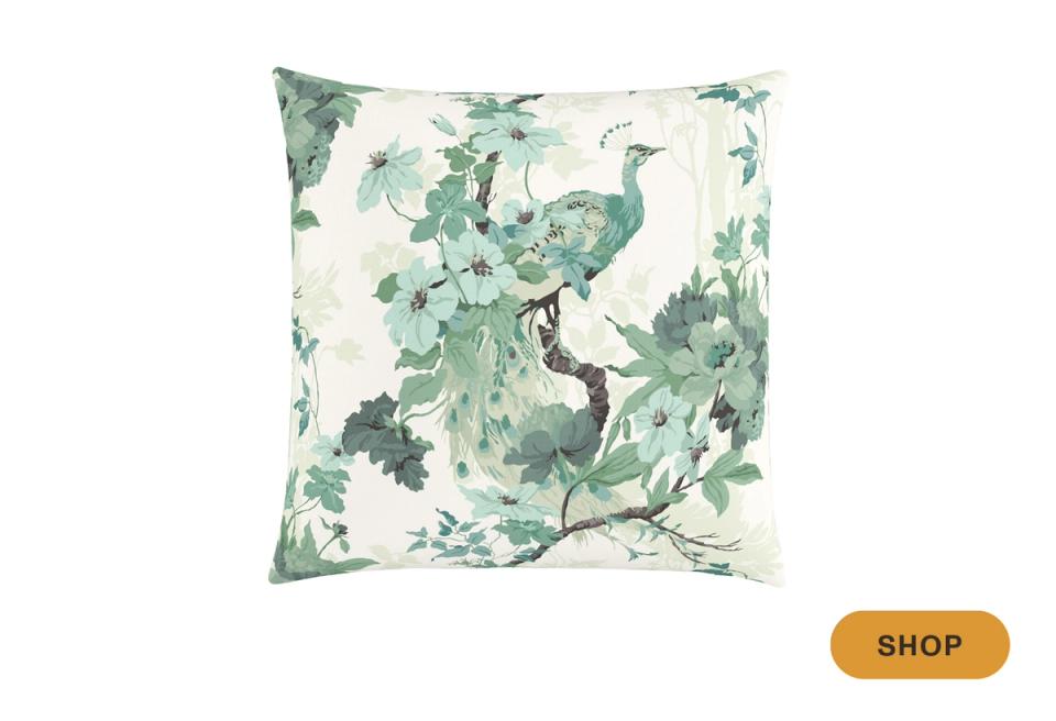Botanical throw pillow with peacock and lush green foliage on cream