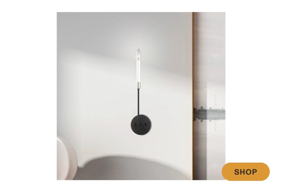 Minimalist black and white pendant sconce with geometric sphere design casting ambient glow