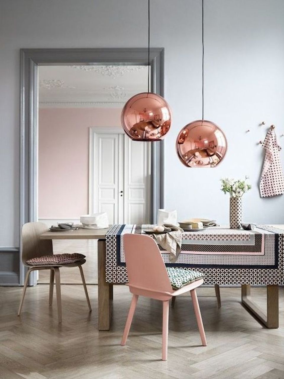 Contemporary dining space with rose gold pendants, blush and black palette, geometric patterns