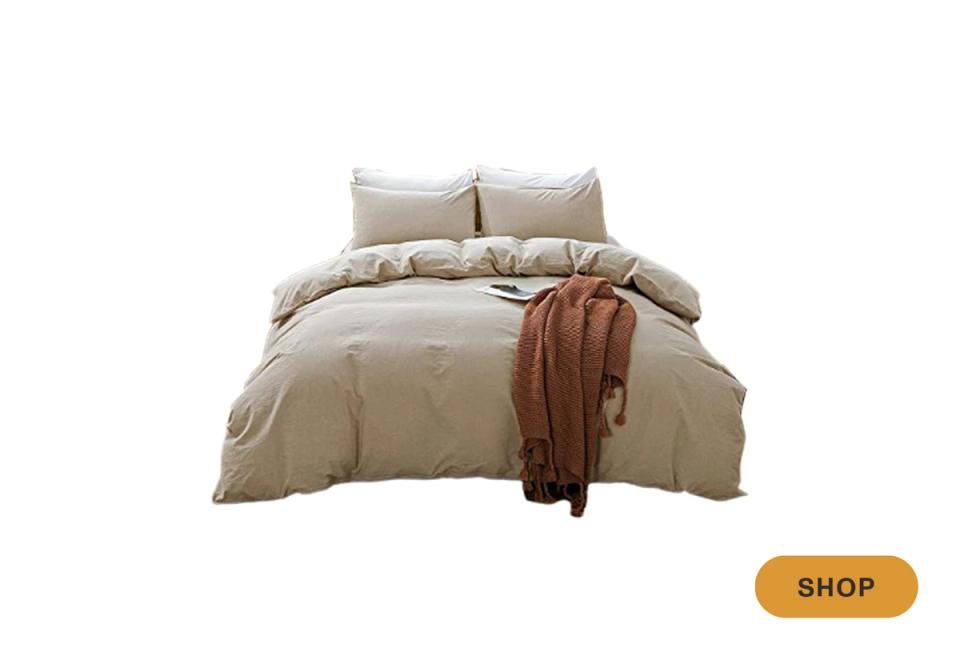 Warm neutral linen bedding set in soft taupe with terracotta throw accent