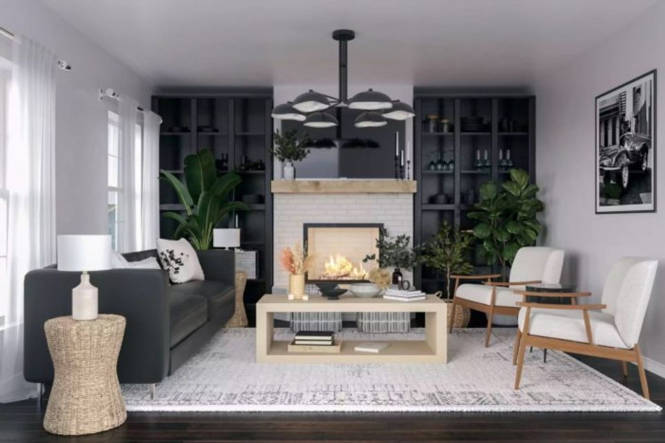 Modern living room with black accent wall, light wood fireplace surround, dark sofa, and lush greenery creating a warm, inviting contemporary space