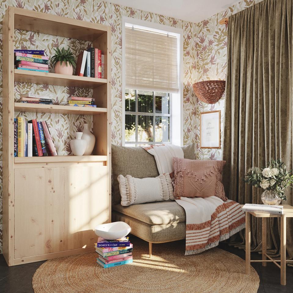 Cottage-style reading corner with botanical wallpaper, natural wood shelving, and rosy tones