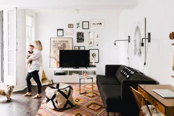 Eclectic gallery wall styled living room with black media console and colorful area rug